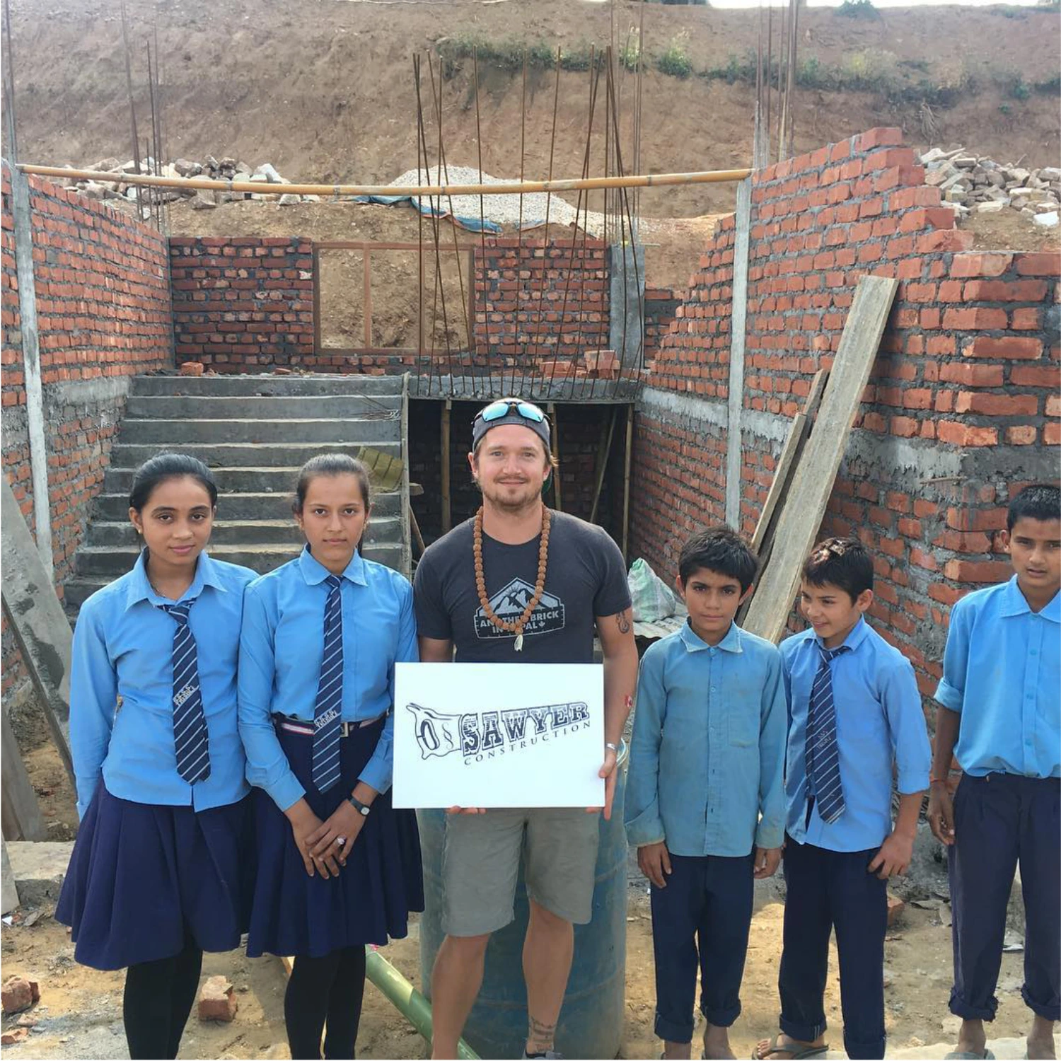 Kyle Sawyer standing with Nepalese school children