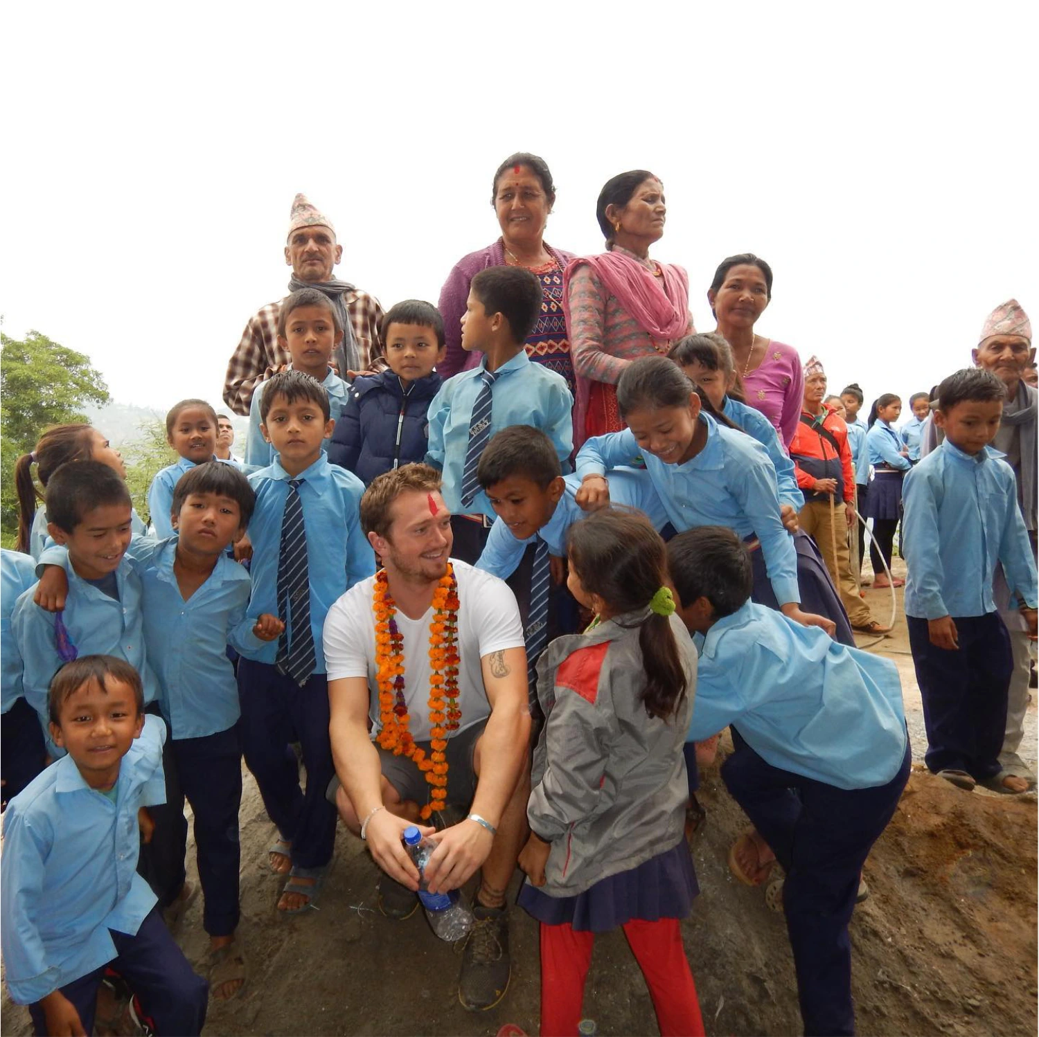 Kyle Sawyer posing with Nepalese school children