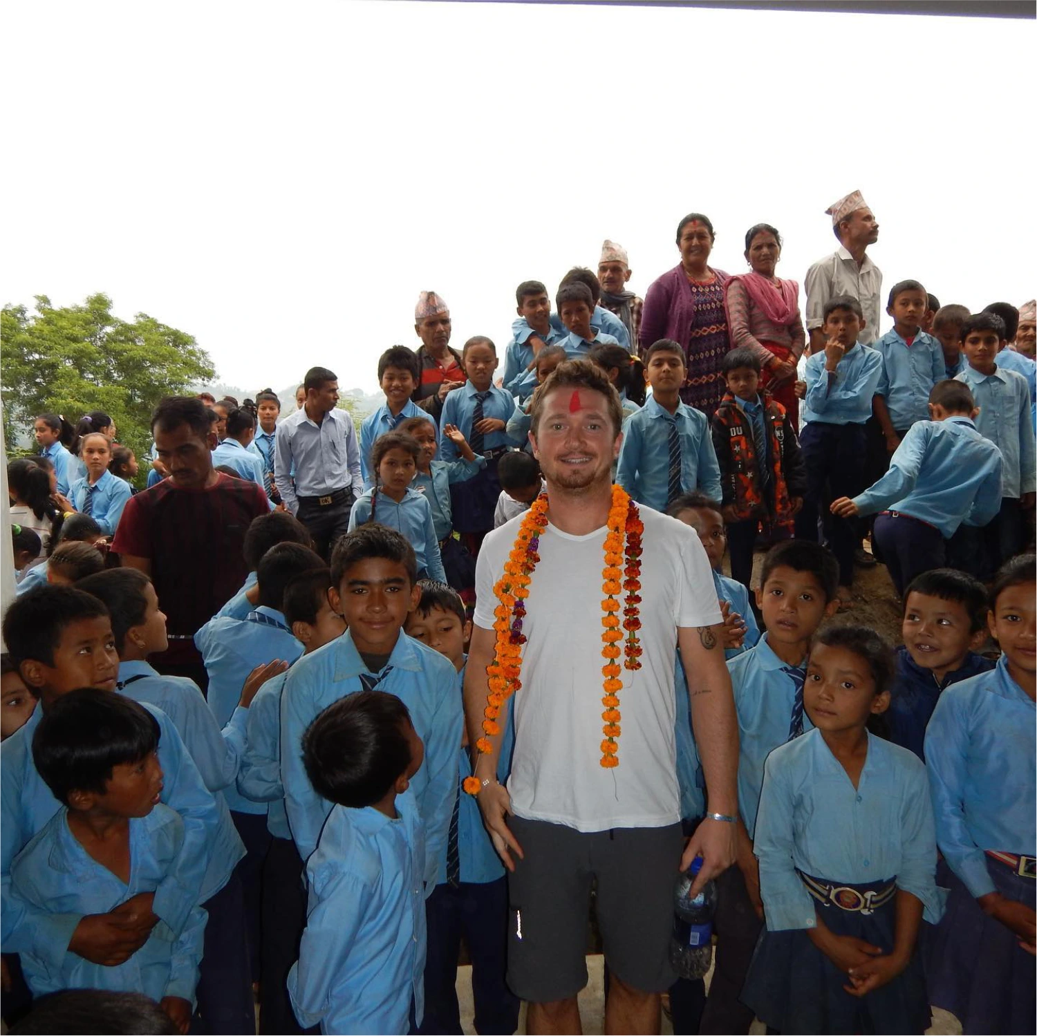Kyle Sawyer posing with Nepalese school children