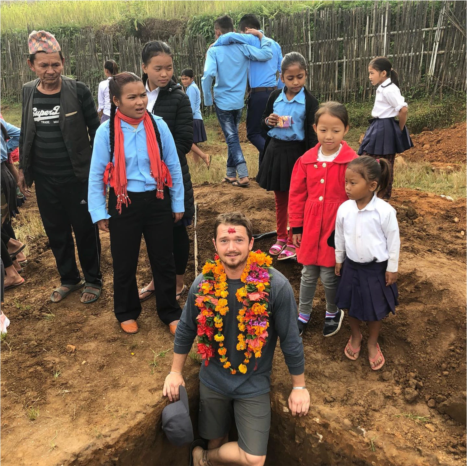 Kyle Sawyer posing with Nepalese school children